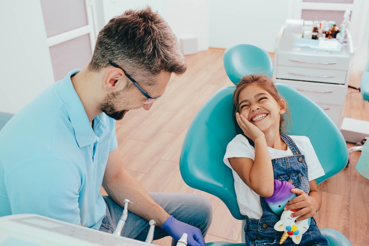 Little-Girl-Laughing-Sitting-On-Dentist-Chair Little Girl Laughing Sitting On Dentist Chair